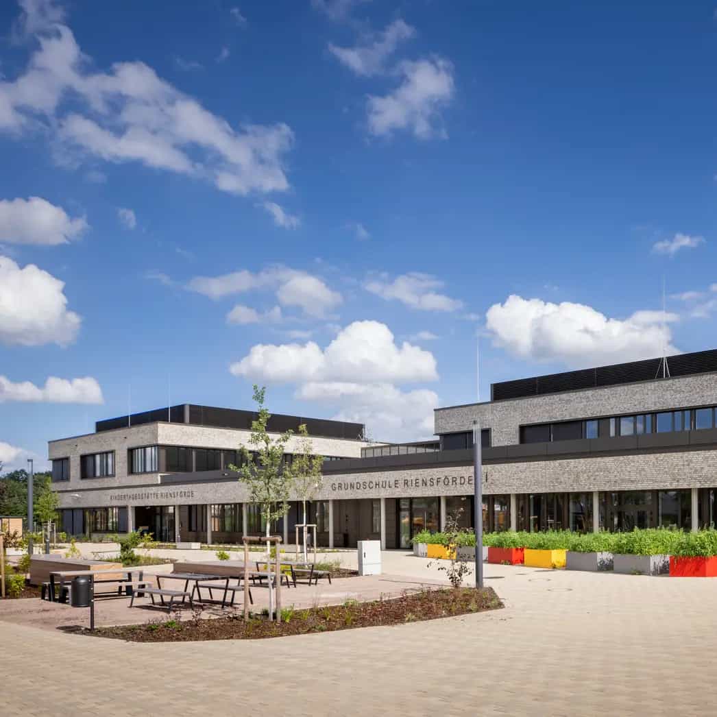 Außenansicht des Bildungscampus Riensförde mit einem großzügigen Pausenhof.