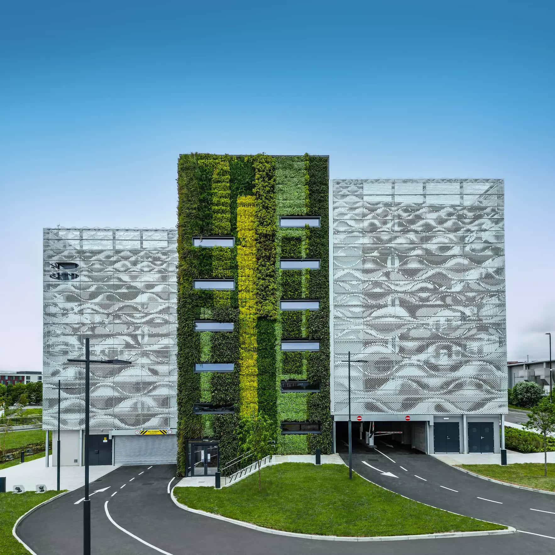 Parkhausreferenz Sunderland in UK mit auffälliger Fassade aus grauen Wellen-Lamellen und durchgängiger Begrünung an der Treppenhaus-Außenfassade.